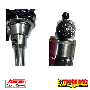 Close-up of two shock absorbers: left chrome strut, right adjustable dial; logos for Al Shiba and Tough Dog at the bottom.